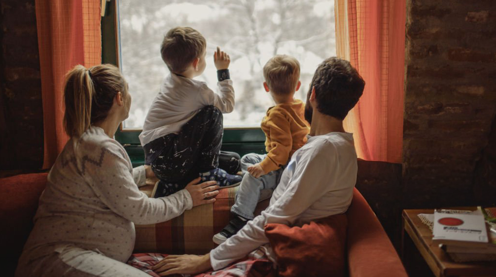 Family looking out window at snow